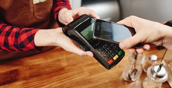 Retail employee taking payment from an employee using phone