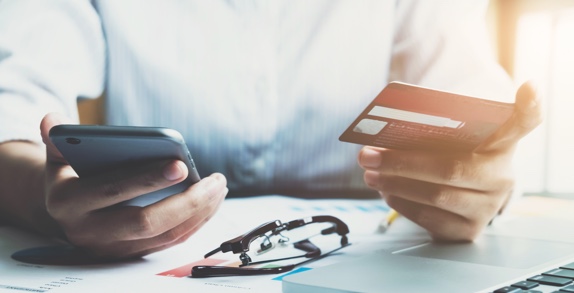 Hands using a mobile phone and credit card