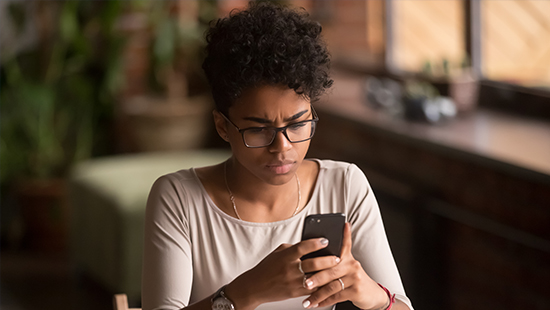 Woman frowning looking at her smartphone