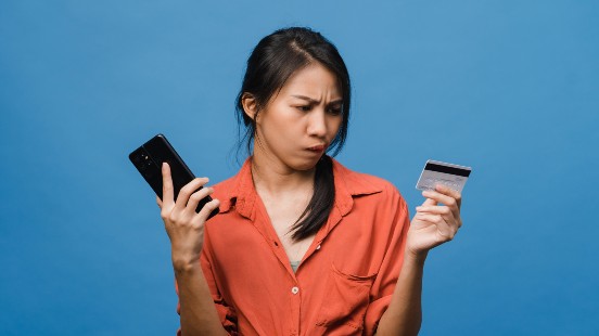 Woman holding a credit card and a phone