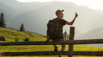 Man sitting on fence in the countryside