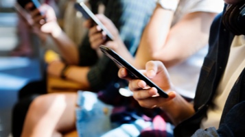 Group of people looking at their own smartphone