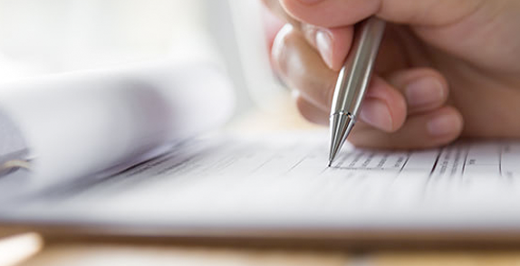 Hand holding mechanical pencil and ticking on a form