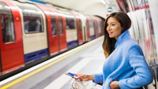 Woman in blue coat waiting for the tube