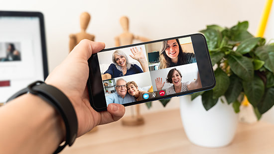 hand holding a phone with a video call on the screen