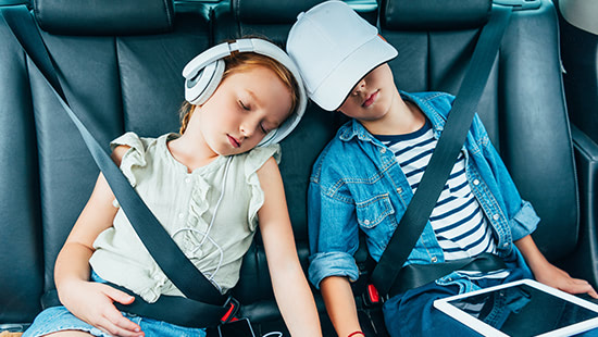 children asleep in a car