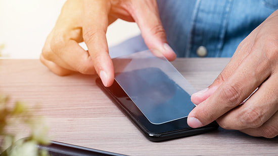 screen protector being placed on a phone