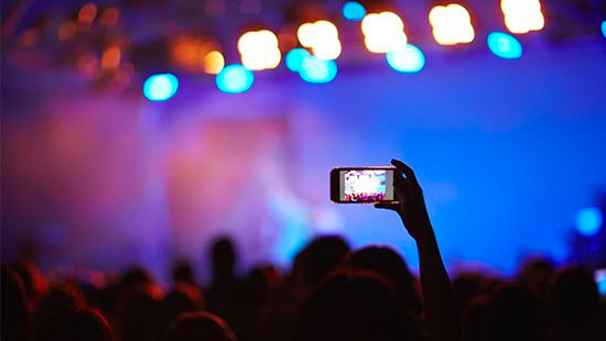 person holding a phone up at a concert