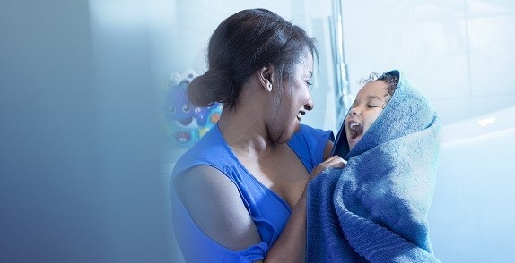 Woman holding baby wrapped in a towel