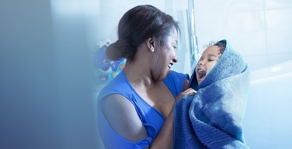 Mother holding a child wrapped up in a towel