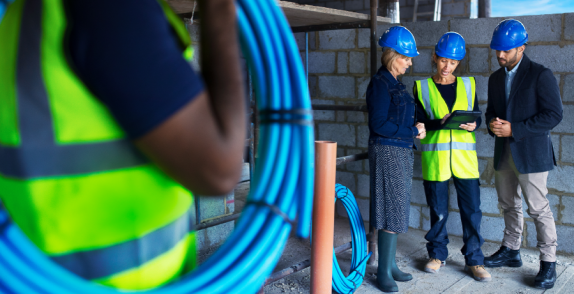 People in on a construction site looking at a tablet