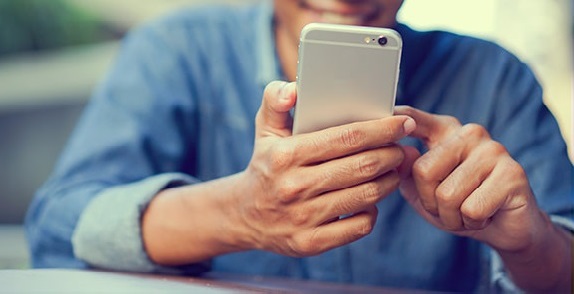 Man using his mobile handset for online financial services with O2 Business