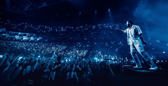 Artist on the O2 arena stage facing a crowd