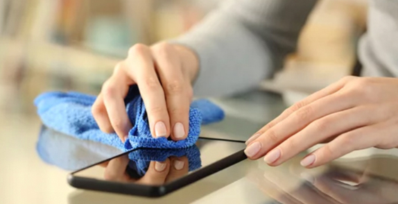 Person wiping phone with cloth