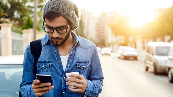 person with coffee holding their phone