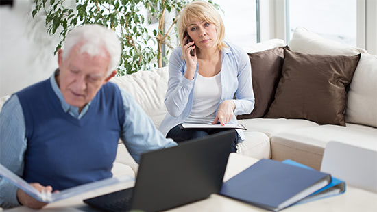 person holding their phone and person sitting with laptop