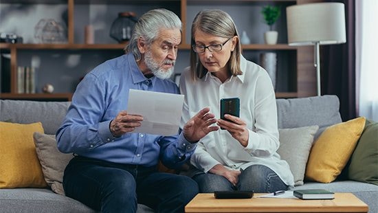 person holding their phone and person holding a letter