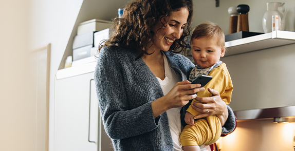 person holding a phone and a baby