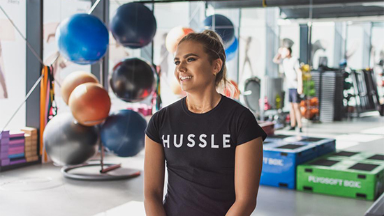 person in a gym wearing a hussle top