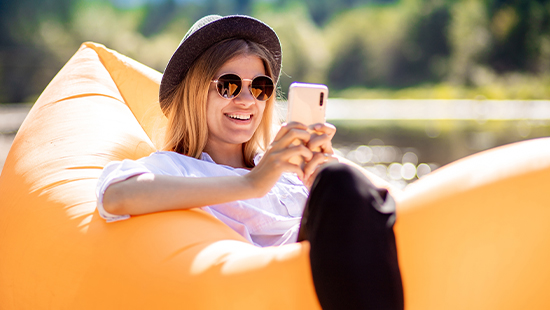 person sitting in the sun with their phone