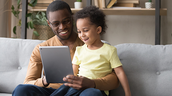 man and child laughing at phone