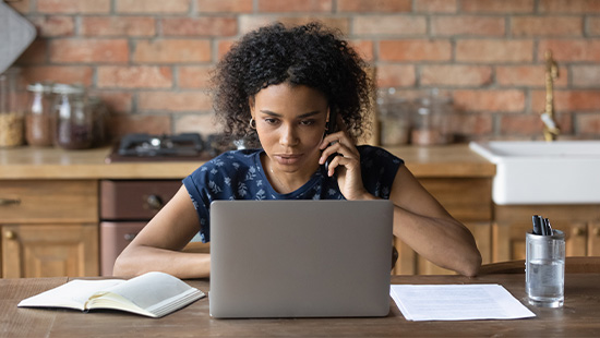 person working at home holding phone to ear