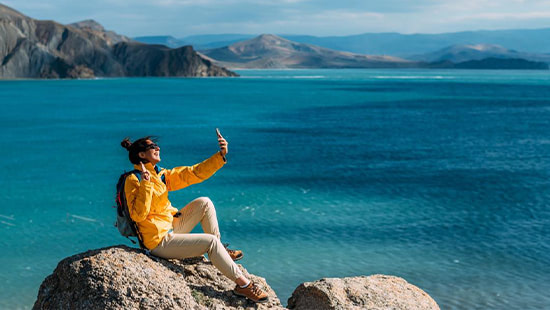 person taking a picture near the sea