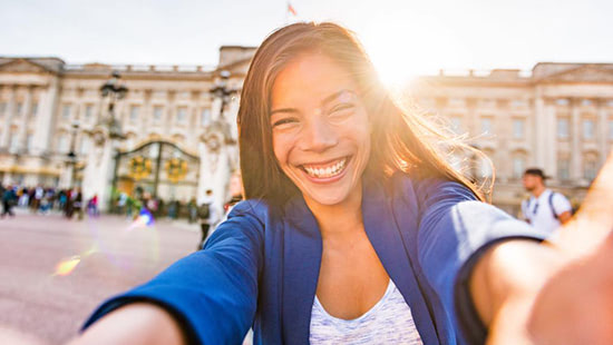 person taking a selfie in front of Buckingham Palace