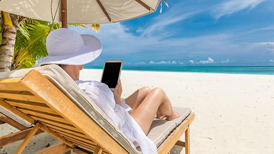 person on a sunbed at the beach holding a phone