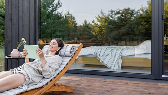 person on a sunbed holding a tablet