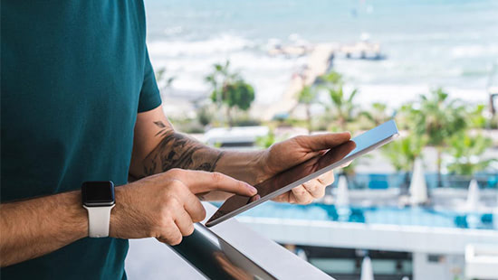 person holding a tablet by a pool