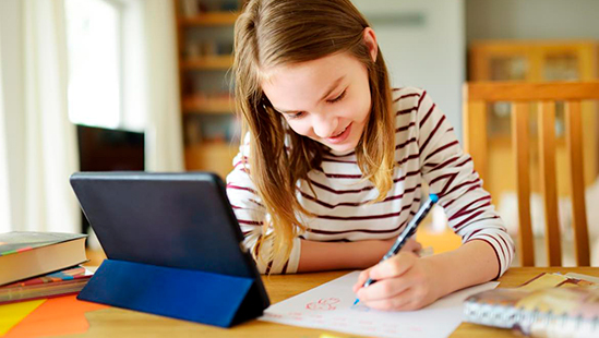 child at a table writing