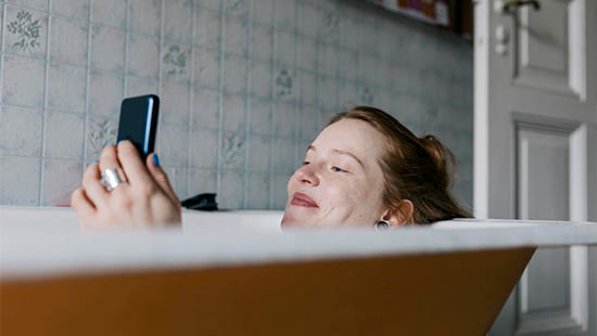 person holding a phone in the bath