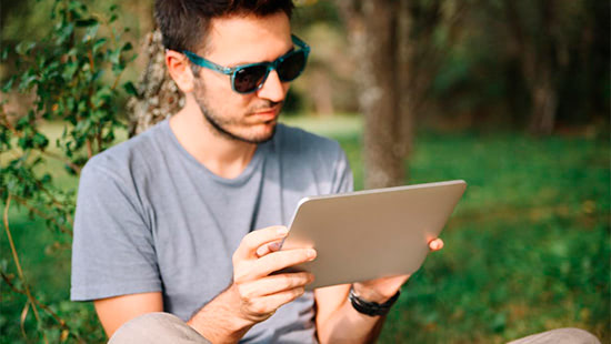 person wearing sunglasses looking at a tablet