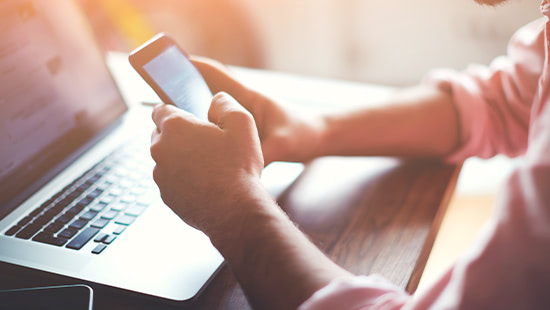 phone being held above a laptop