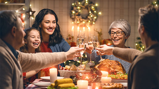 people holding glasses over a table of food