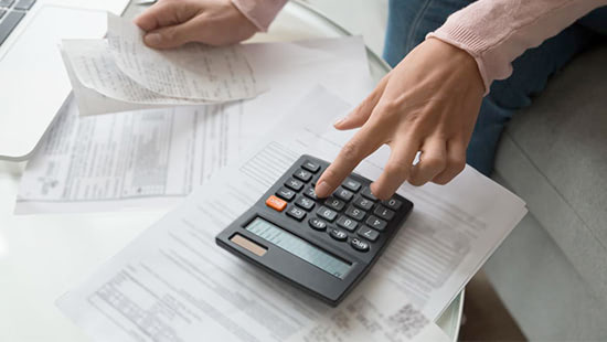 Hand inputting numbers into calculator