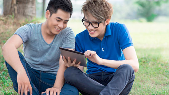 Teenage boys sitting together looking at a tablet