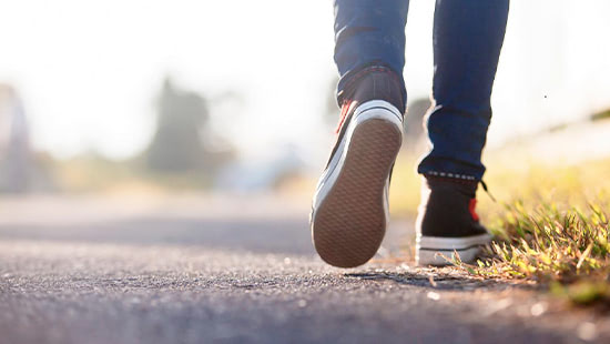 Photo of trainers and legs walking along a road